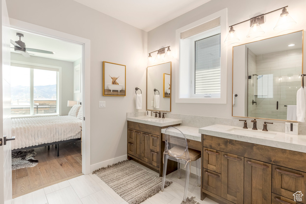 Ensuite bathroom with double vanity, a stall shower, and a ceiling fan
