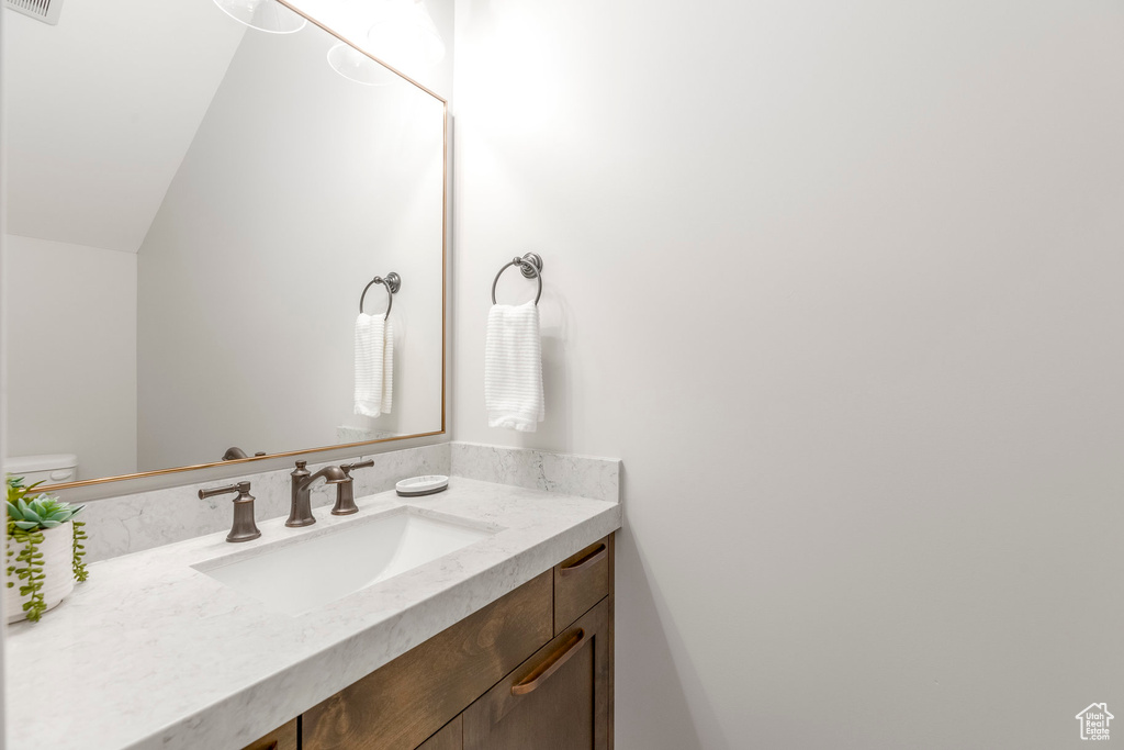 Bathroom with vanity and lofted ceiling