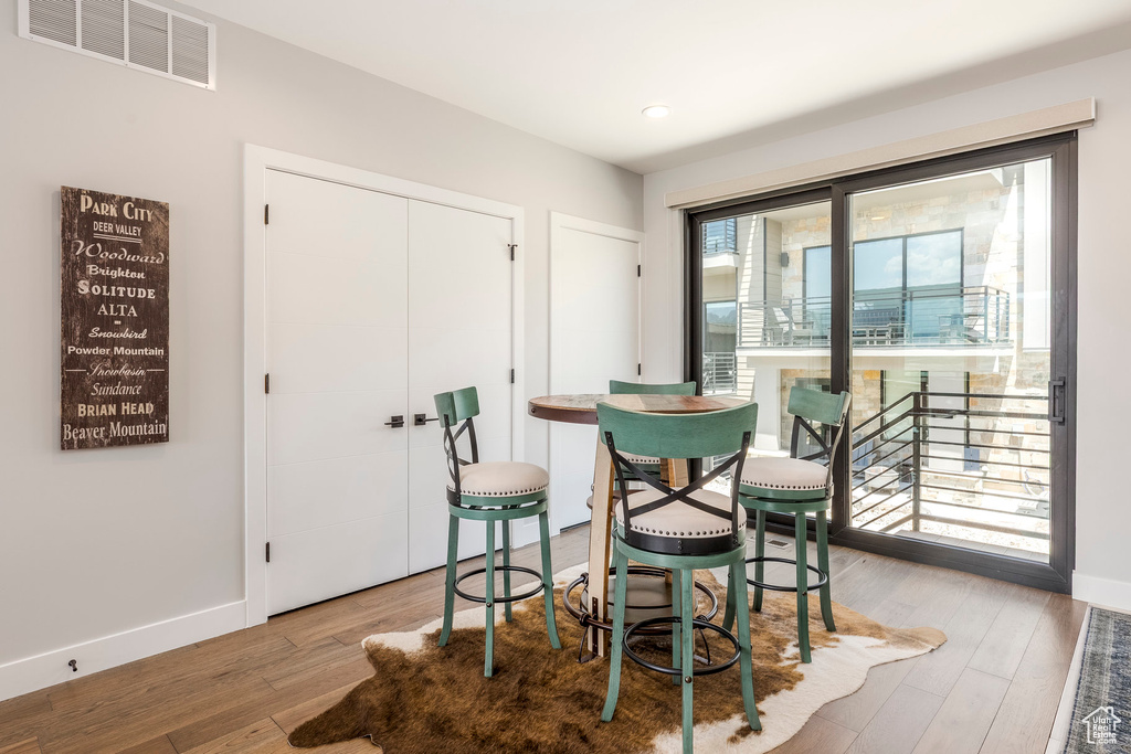 Dining area with wood finished floors, recessed lighting, and a fireplace