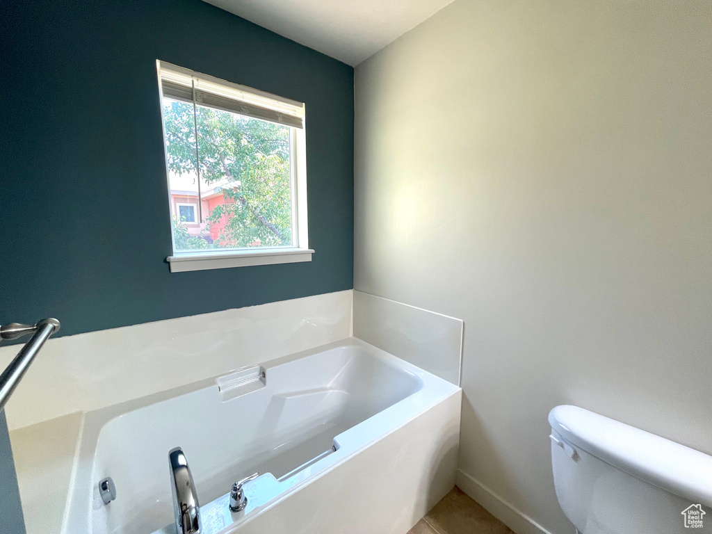 Full bathroom featuring a garden tub and tile patterned flooring