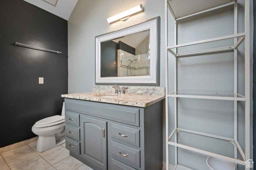 Full bathroom with vanity, tile patterned floors, and a shower