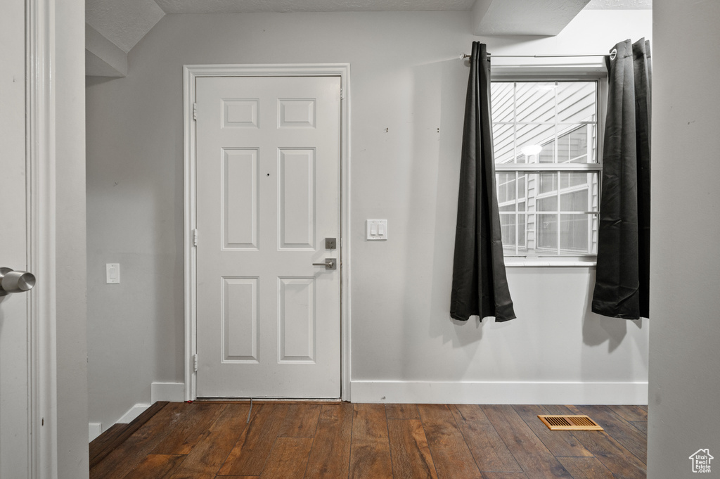 Foyer entrance with dark wood-style floors and baseboards