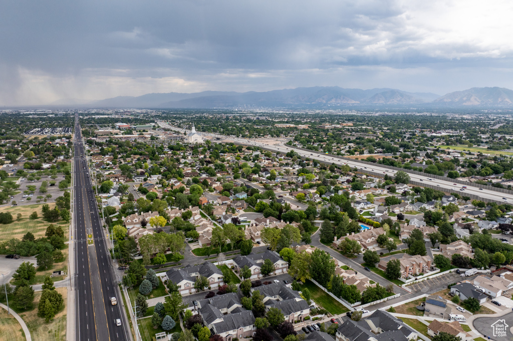 Aerial perspective of suburban area featuring a highway and a mountainous background