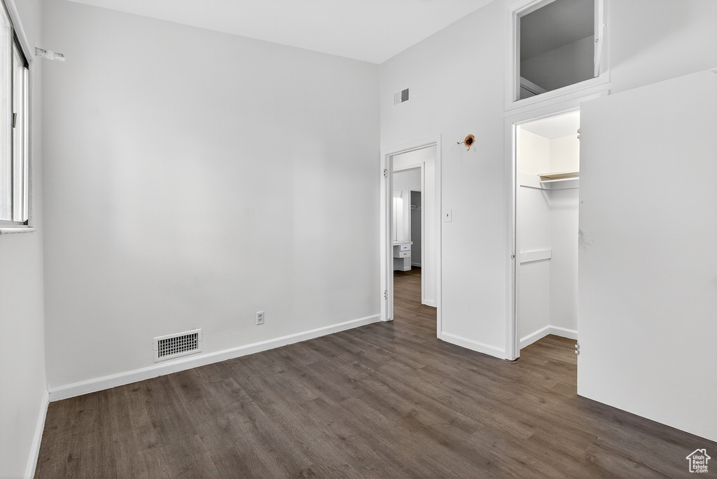 Unfurnished bedroom with dark wood-style flooring and baseboards