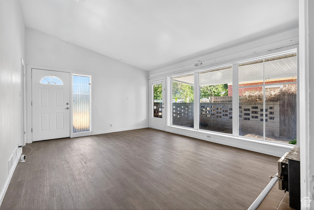 Unfurnished sunroom featuring lofted ceiling