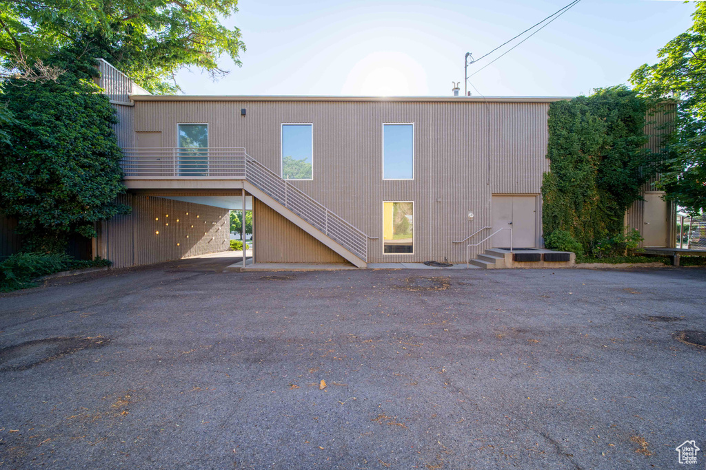 Back of house with stairs, driveway, and entry steps