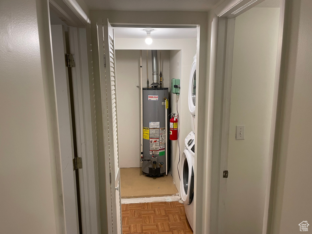 Laundry area with gas water heater and estacked washer and dryer