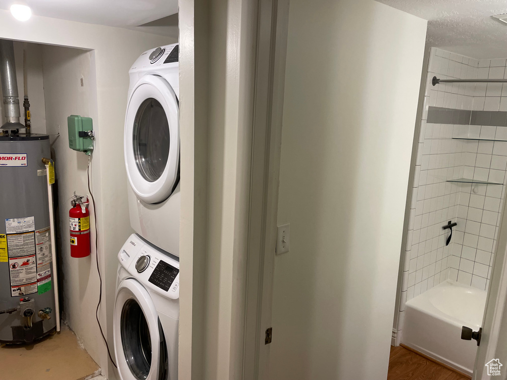 Washroom featuring gas water heater and estacked washer and dryer