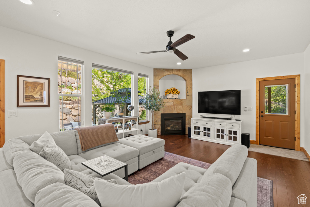 Living room featuring healthy amount of natural light, ceiling fan, dark wood-style flooring, a fireplace, and recessed lighting
