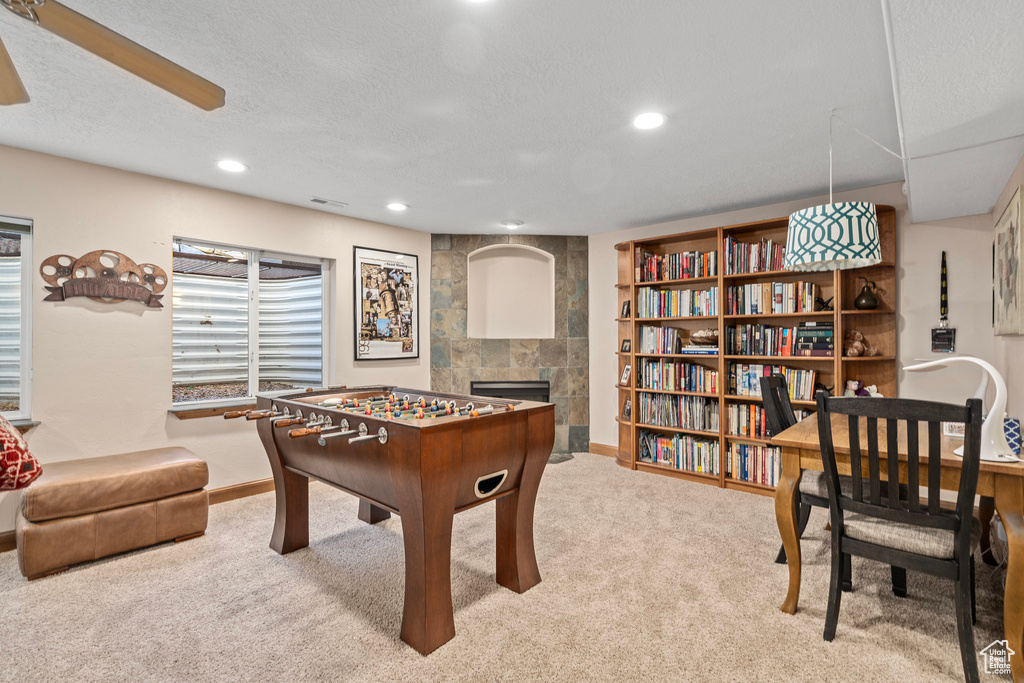 Game room featuring a fireplace, carpet, recessed lighting, a textured ceiling, and ceiling fan