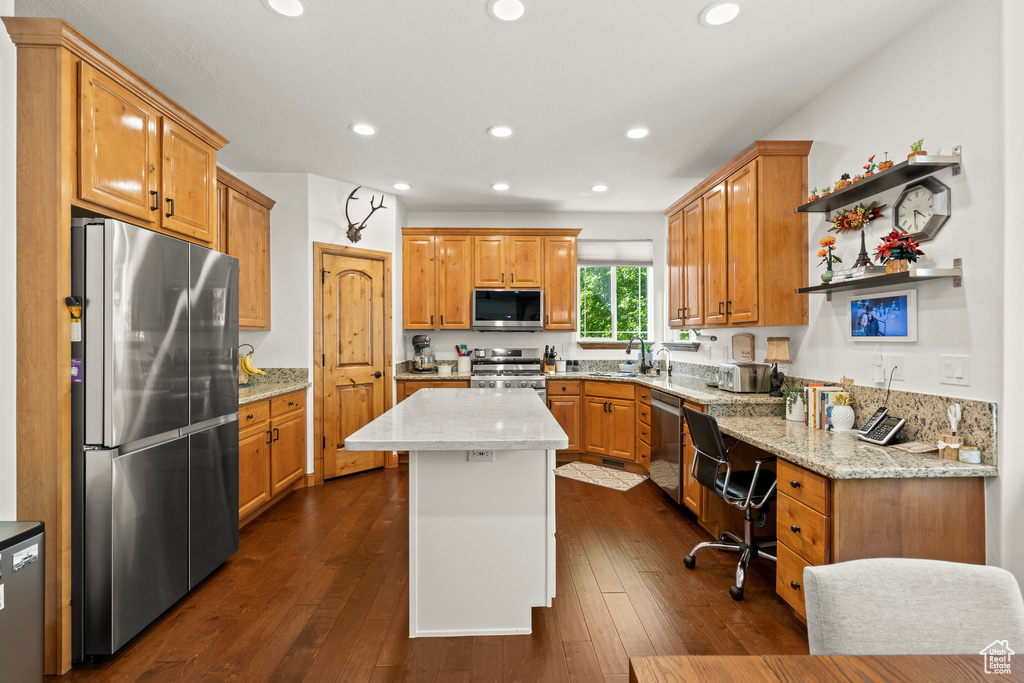 Kitchen with stainless steel appliances, recessed lighting, light stone counters, a kitchen island, and dark wood-style floors