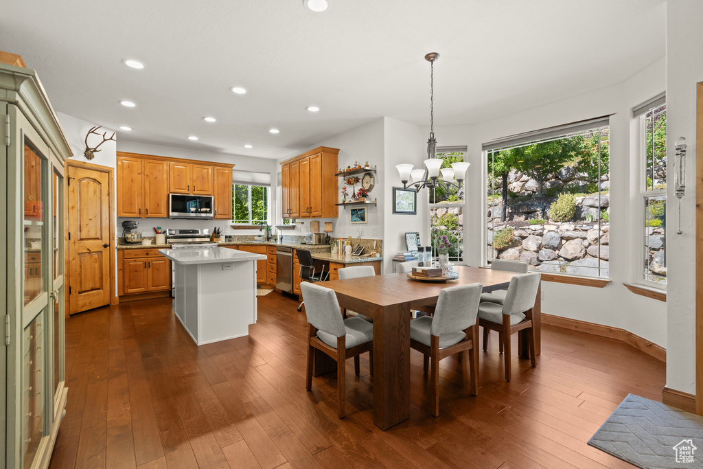 Dining area with recessed lighting, dark wood-style floors, and a chandelier