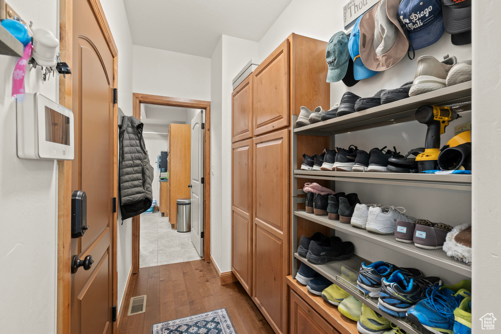 Walk in closet featuring dark wood-style flooring