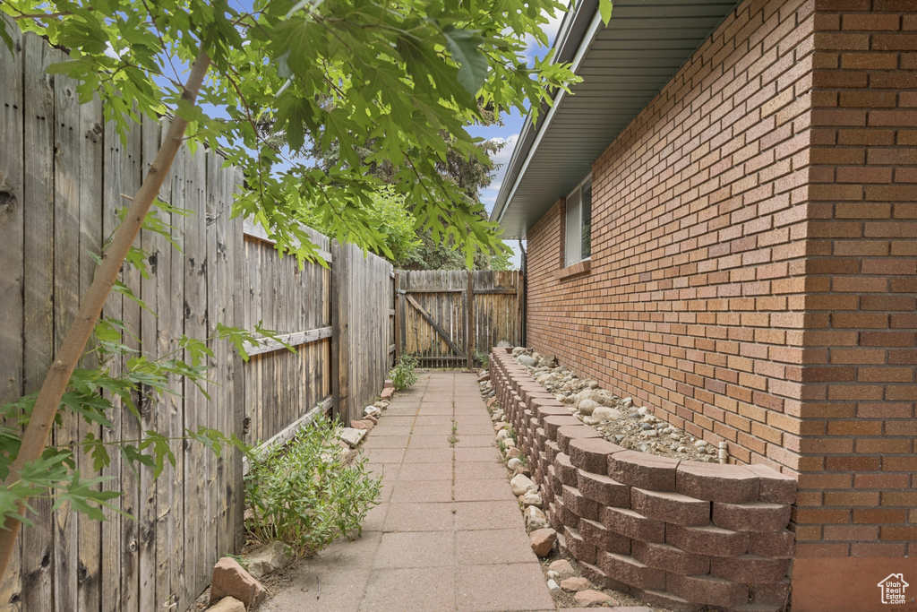 View of side of property featuring brick siding and a fenced backyard