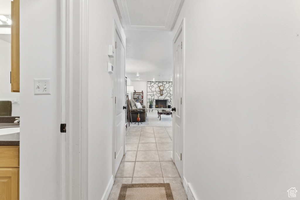 Corridor featuring light tile patterned floors and ornamental molding