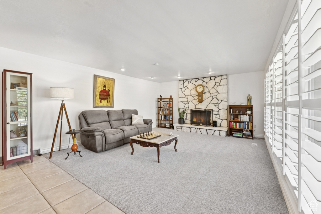Tiled living room featuring a fireplace and baseboards