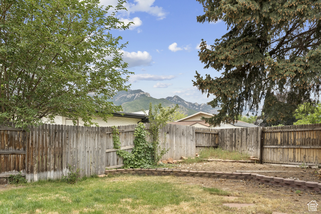 Fenced backyard featuring a mountain view