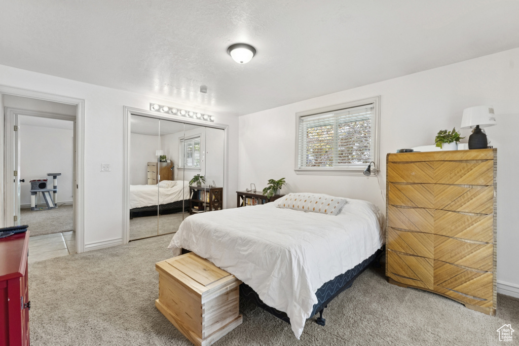 Carpeted bedroom featuring a closet and baseboards