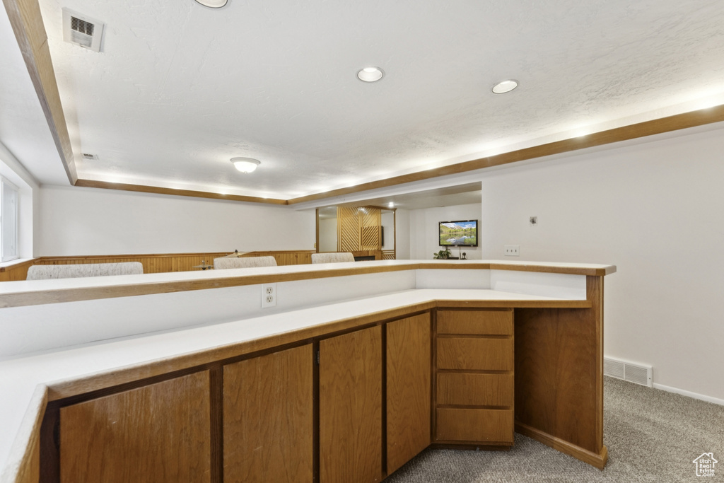 Kitchen with light colored carpet, light countertops, brown cabinets, and recessed lighting
