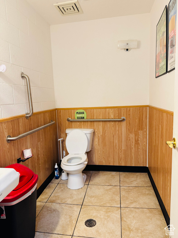 Bathroom featuring wainscoting, wooden walls, and tile patterned floors