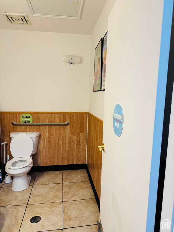 Bathroom featuring wainscoting, tile patterned floors, and wooden walls