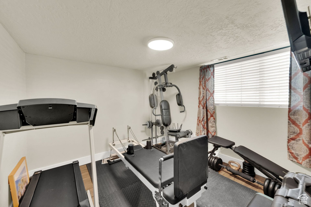Workout room with a textured ceiling and wood finished floors
