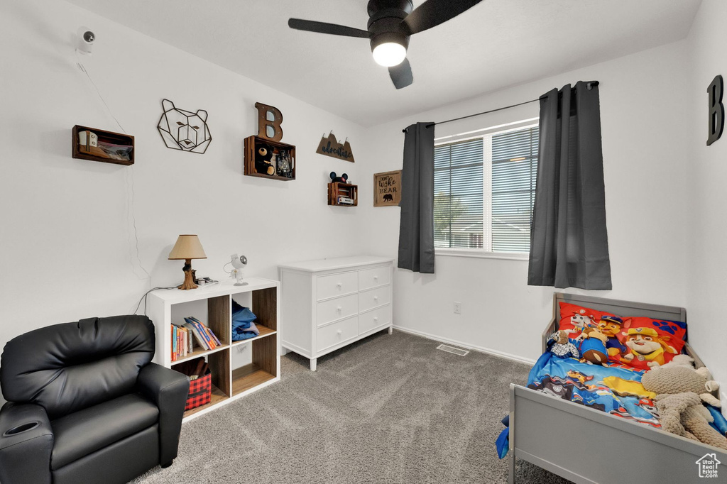 Bedroom with dark carpet and a ceiling fan