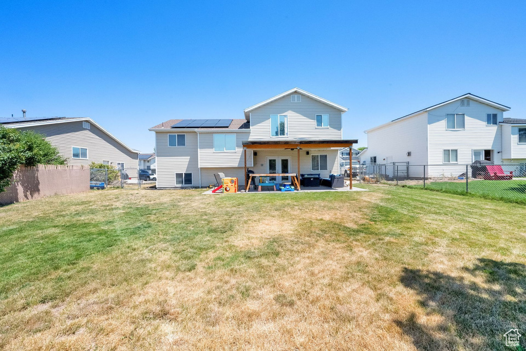 Back of property with french doors, a patio area, a fenced backyard, and an outdoor living space