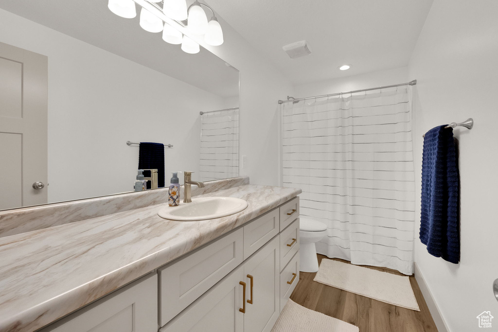 Full bath featuring vanity, wood finished floors, recessed lighting, and curtained shower
