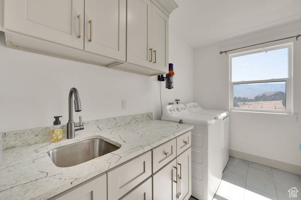 Washroom with cabinet space, washing machine and dryer, and light marble finish floors