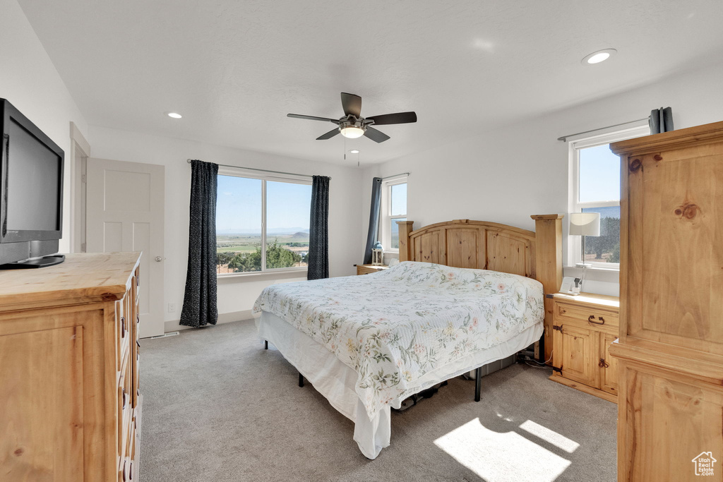 Bedroom featuring light carpet, multiple windows, recessed lighting, and a ceiling fan