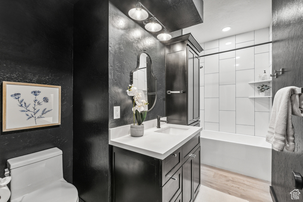 Full bath with vanity, wood finished floors, and shower / bath combination