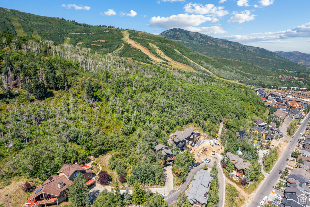 Aerial view of property and surrounding area featuring a mountain backdrop and nearby suburban area