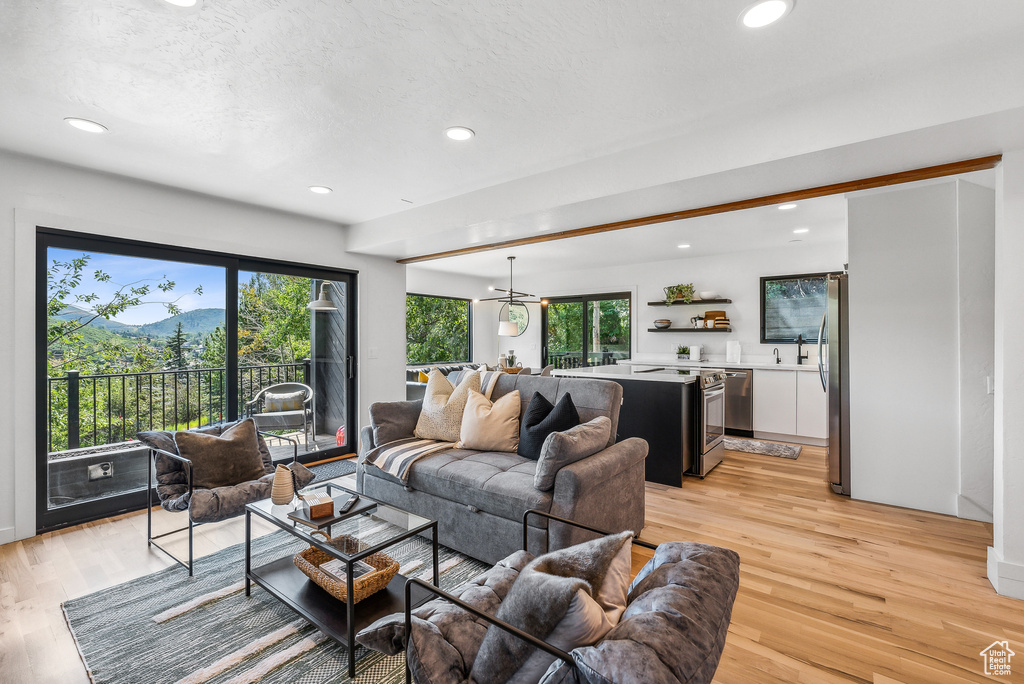 Living area with healthy amount of natural light, light wood finished floors, recessed lighting, and a mountain view