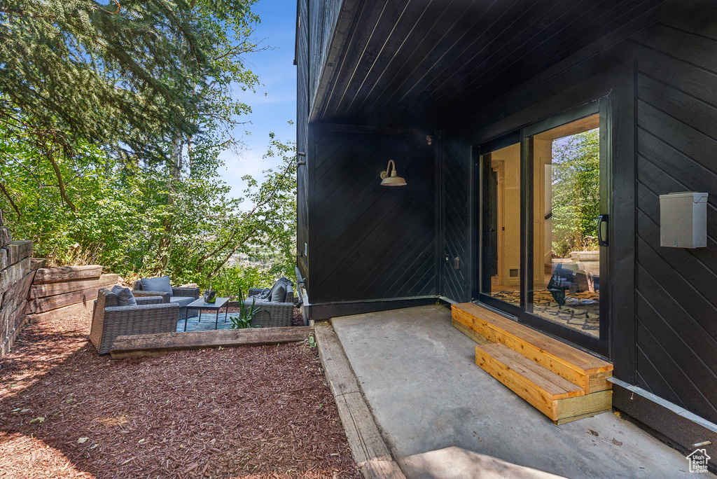 Property entrance with a patio and outdoor lounge area