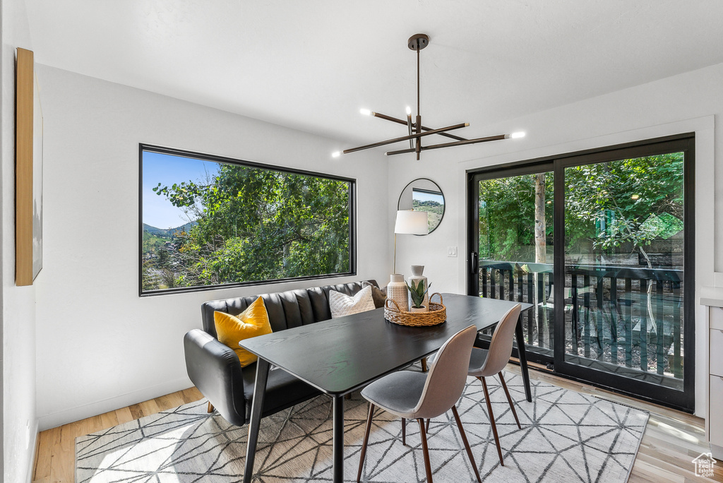 Dining room with plenty of natural light, a chandelier, and light wood finished floors