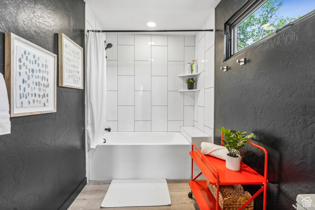 Full bathroom featuring shower / tub combo with curtain and wood finished floors