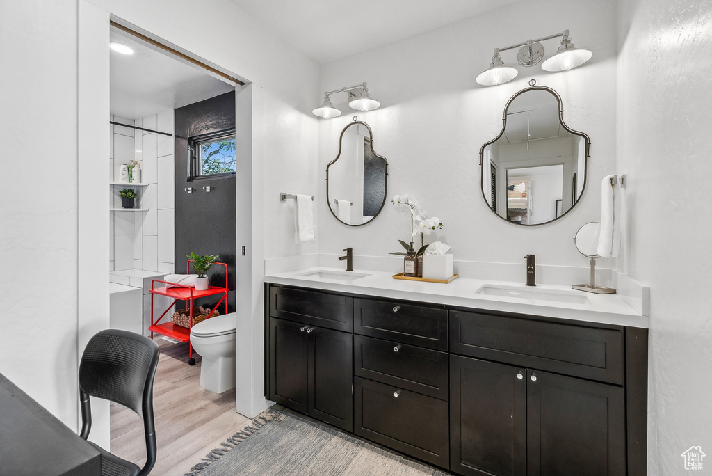 Full bath with double vanity and wood finished floors