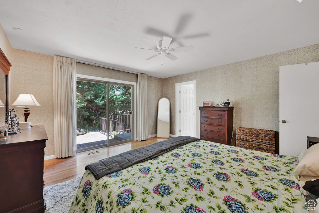Bedroom with access to exterior, wood finished floors, and a ceiling fan