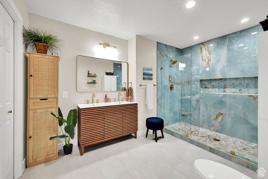 Full bathroom with a marble finish shower, double vanity, recessed lighting, and tile patterned flooring