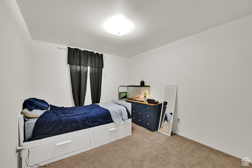 Bedroom featuring light carpet and baseboards