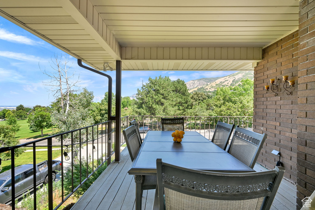 Wooden deck with a mountain view and view of scattered trees