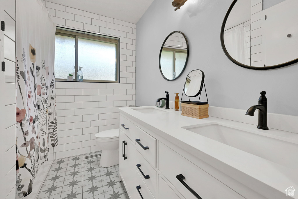 Full bathroom featuring double vanity, tile patterned floors, and a shower with curtain