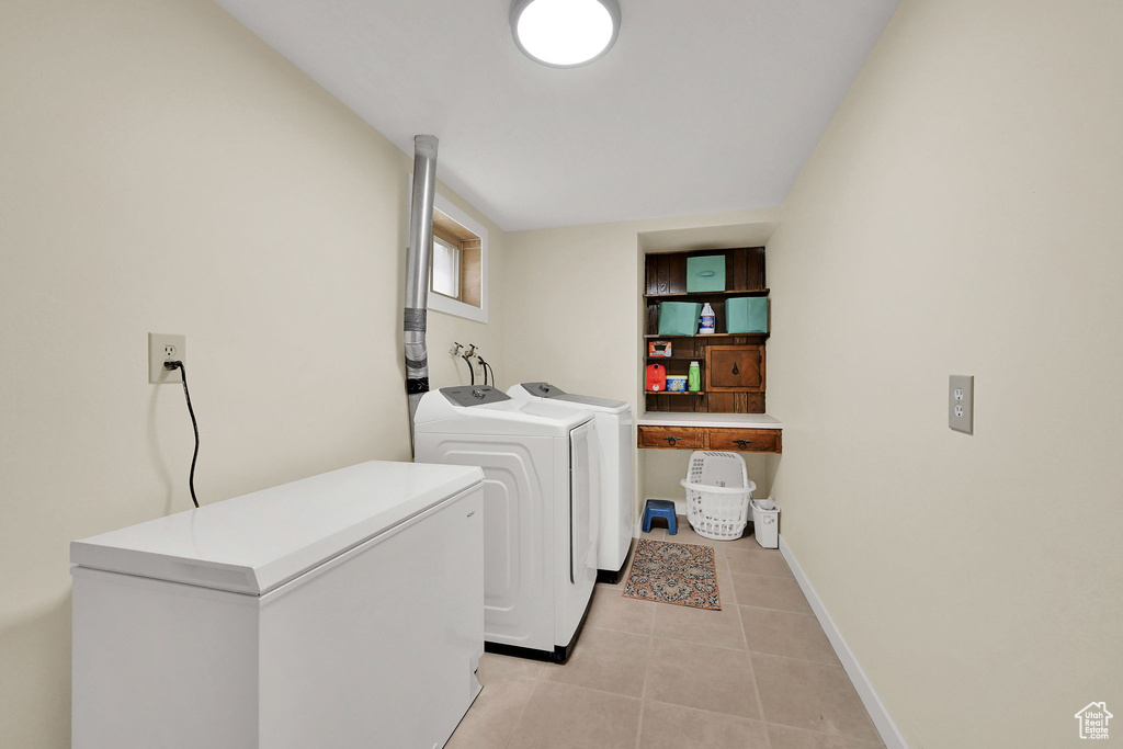 Laundry room featuring washing machine and clothes dryer and light tile patterned floors