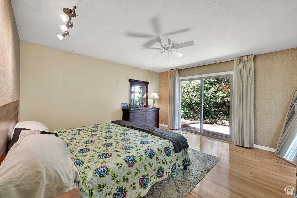 Bedroom with access to outside, wood finished floors, and a ceiling fan