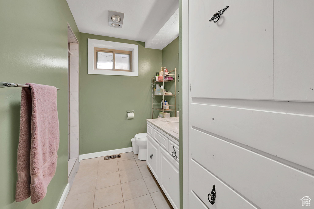 Bathroom with tile patterned floors, vanity, and a shower