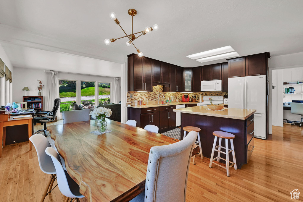 Dining area featuring light wood-style flooring and a chandelier