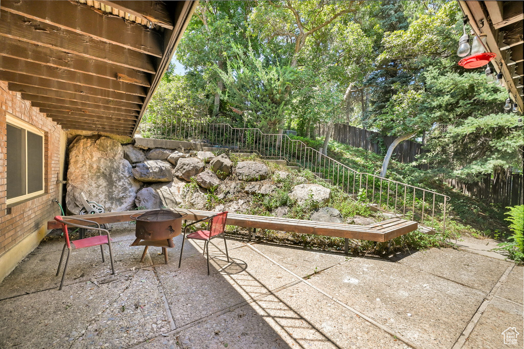 Fenced backyard featuring a patio area and a fire pit