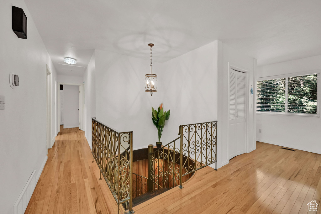 Corridor with an upstairs landing and wood finished floors