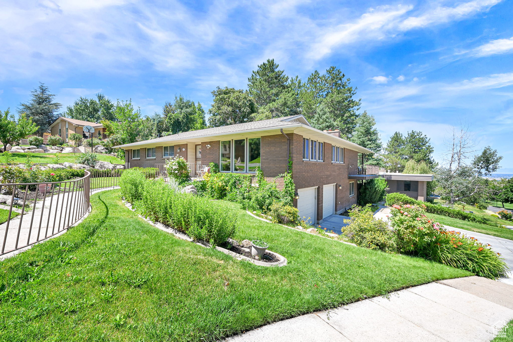 View of front of house featuring brick siding, an attached garage, and driveway